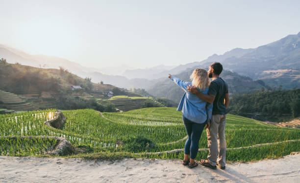 Young Caucasian couple overlooking rice terraces of Sapa at sunset in Lao Cai region of Vietnam stock photo