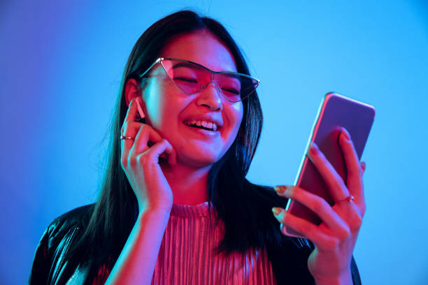 istock Beautiful girl's facial expression in neon light on blue studio background 1164899669