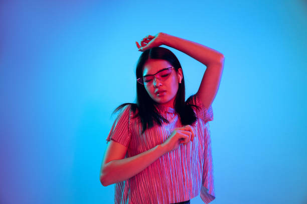 istock Beautiful girl's facial expression in neon light on blue studio background 1164899761