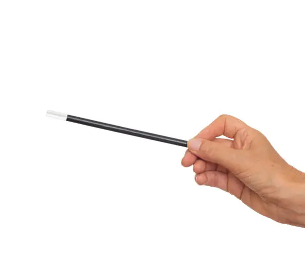 Female hand with traditional magician's black and white magic wand isolated on white.