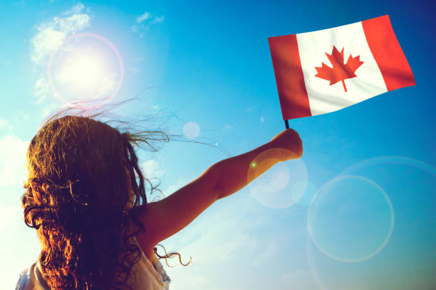 Little girl waving Canadian flag on sunny beautiful day