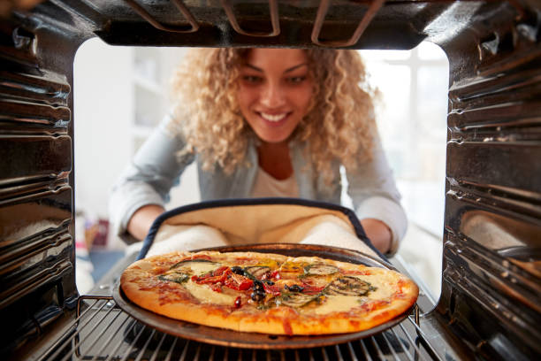 View Looking Out From Inside Oven As Woman Cooks Fresh Pizza View Looking Out From Inside Oven As Woman Cooks Fresh Pizza convenience food photos stock pictures, royalty-free photos & images