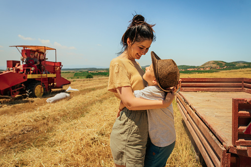 Mother and son in a wheat field during harvesting