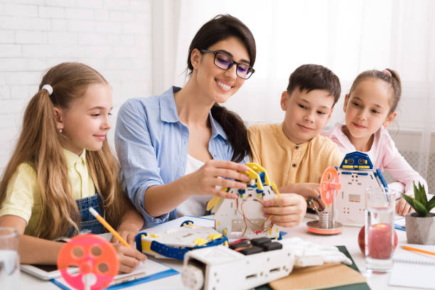 istock Kids creating robots with teacher at stem education class 1164902632