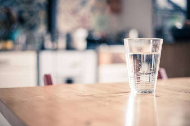 istock Clear glass of fresh, cold water on the kitchen table 1164904139