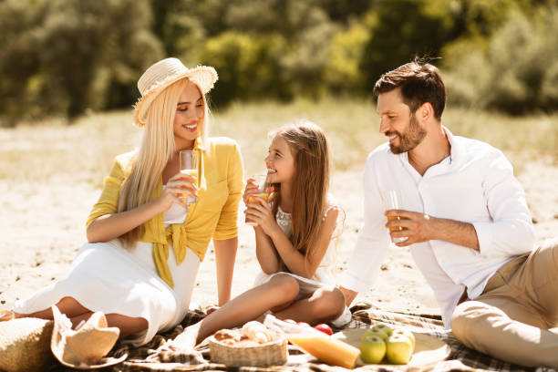 istock Young family having picnic outdoors, resting in nature 1164904175