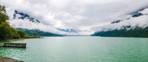 ブリエンツェルゼー、雲の中に曇りアルプスの山々とブリエンツの湖。パノラマ。インターラーケン、カントンベルン、スイス - nautical vessel sailboat interlaken switzerland ストックフォトと画像