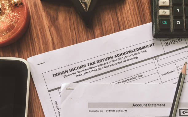 close up of indian income tax return form itr-2 return form is on the table next to a pen, calculator and a home mortgage loan application form placed on the desk. - endorsing business application form filling imagens e fotografias de stock