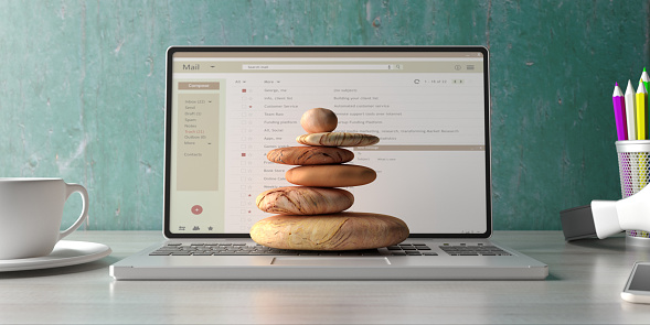 Zen stones stack on a computer laptop office desk background. Relax and stress free at work concept. 3d illustration