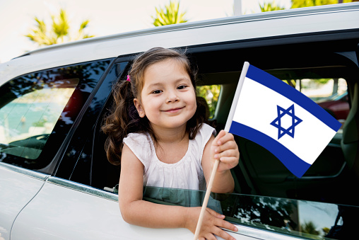 Girl holding Israel flag in the car.