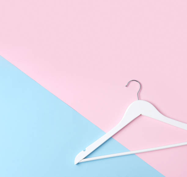 istock Top view flat lay single white wooden hanger pink and blue pastel background. 1164919210