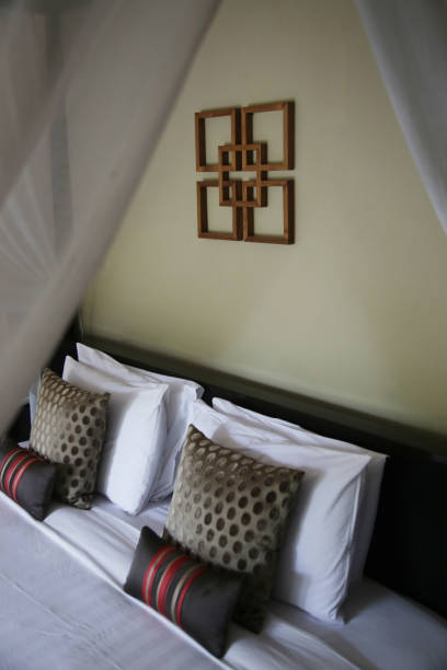 istock Bed with white linen, pillows and mosquito net. Vintage Interiors. Bed with canopy net. 1164920890
