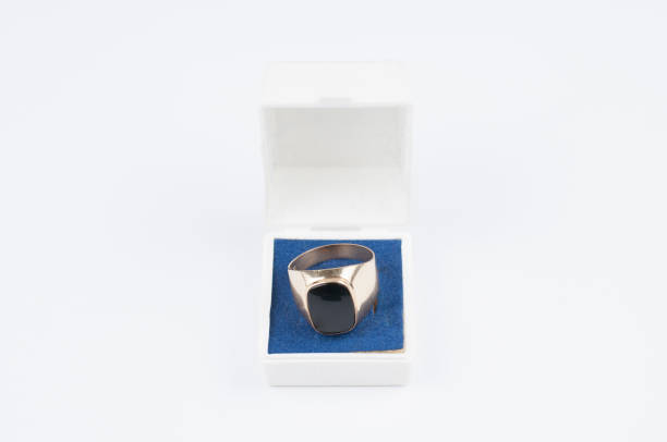 istock Male golden ring with black stone in a box isolated on a white background. 1164922526