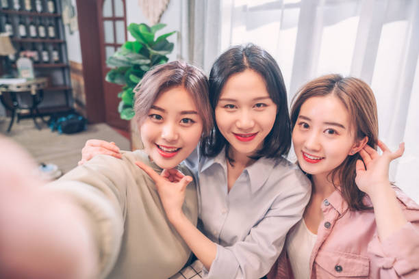 istock young asian girls using smart phone taking a selfie 1164922633