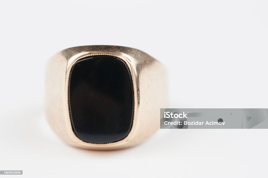 Male golden ring with black stone isolated on a white background. Male golden ring with black stone isolated on a white background Ring - Jewelry Stock Photo