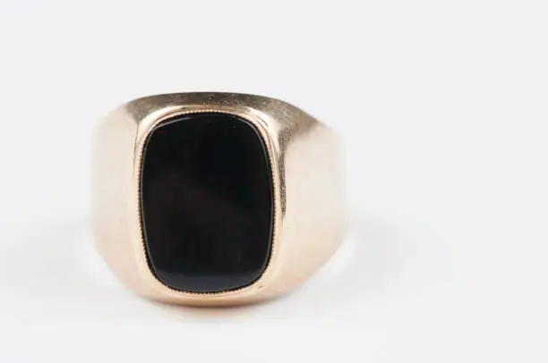 Male golden ring with black stone isolated on a white background
