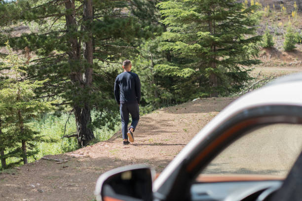 Young man walking in the beautiful forest outdoors.