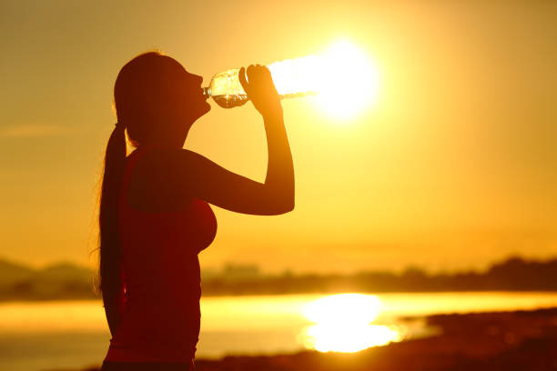 istock Sportswoman drinking bottled water after sport 1164927977