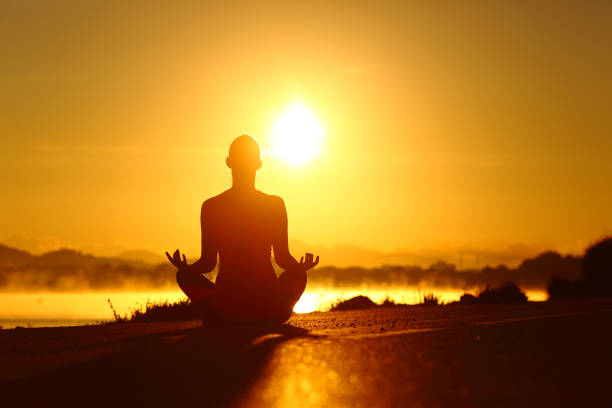 istock Woman silhouette practicing yoga exercise at sunrise 1164927987