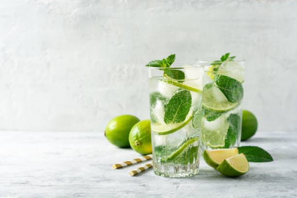istock Fresh mojito cocktail with lime and mint in glass on concrete background. Cold refreshing drink. 1164929595