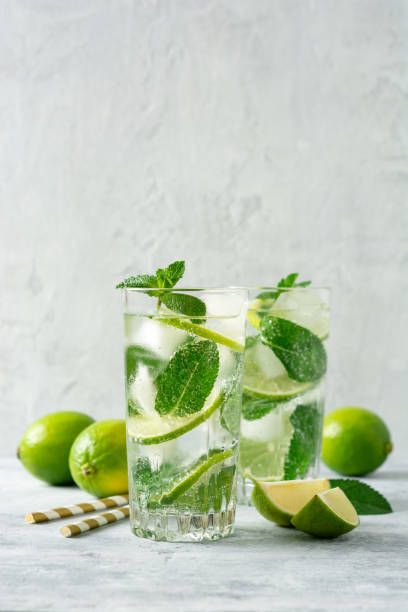 istock Fresh mojito cocktail with lime and mint in glass on concrete background. Cold refreshing drink. 1164929596