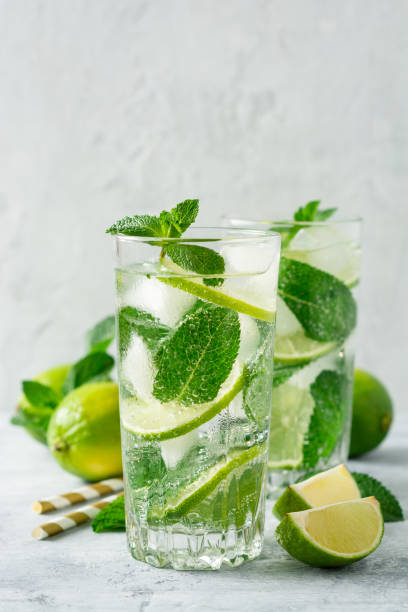 istock Fresh mojito cocktail with lime and mint in glass on concrete background. Cold refreshing drink. 1164929708