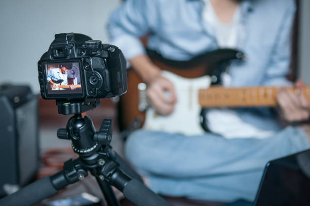 chitarrista che registra un video di se stesso mentre suona una chitarra elettrica nello studio della camera da letto - guitar music guitarist recording studio foto e immagini stock