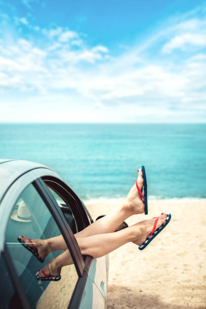 istock Woman relaxing in a car on the beach 1164934892