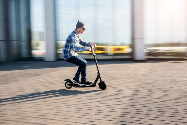istock Young man on electric scooter on street 1164937303