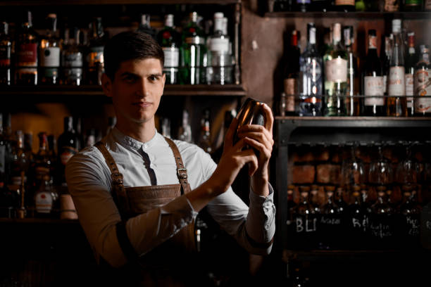 istock Portrait of young bartender in apron preparing cocktail 1164938105
