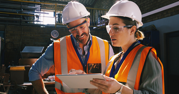 Shot of two engineers using a digital tablet together in an industrial place of work