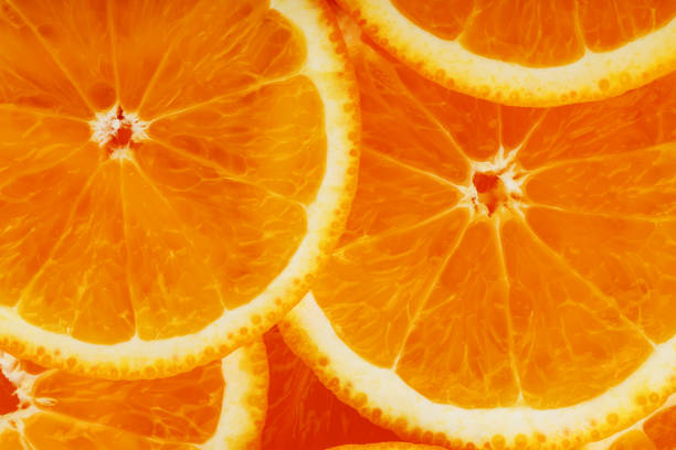 istock Slices of ripe orange backlit as a textural background. Full screen, close-up, macro 1164942904