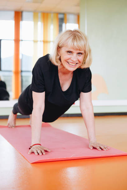 istock Mature woman doing yoga indoor 1164943479