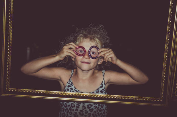 little child behind empty frame in dark black background at night
