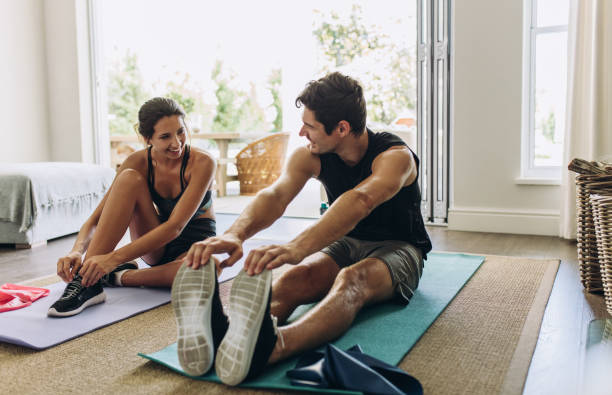 pareja haciendo ejercicio juntos en casa - stretching boyfriend indoors lifestyles fotografías e imágenes de stock