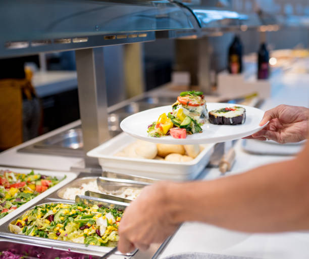 istock man picks up food at the buffet 1164950812