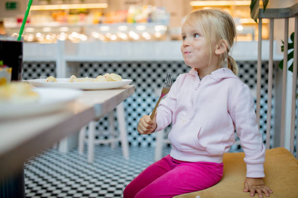 istock little girl eating dumpling in cafe 1164950819