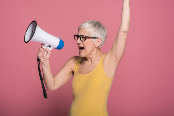 istock Mature woman shouting in megaphone 1164952776