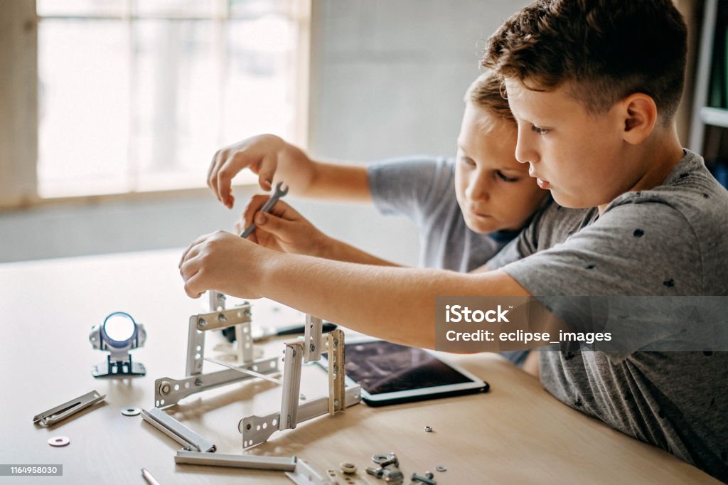 We have to do ourselves to make best machine on world Kids working on diy project, making small robot Child Stock Photo