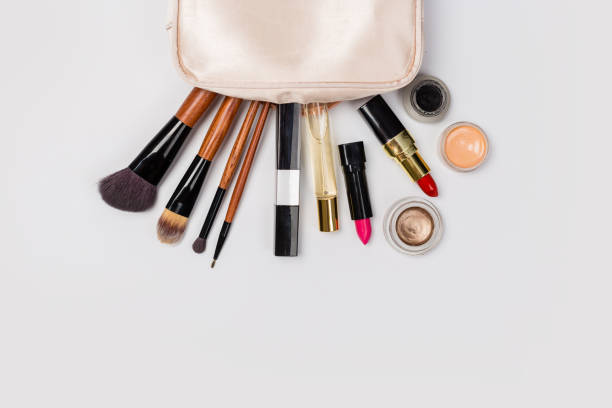 istock Makeup products with cosmetic bag and macaroons on light background 1164959379