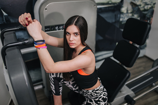 Vital and determined motivated woman exercising at a gym.