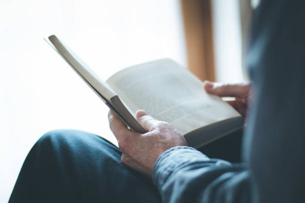 istock Senior man is reading a book at home, selective focus 1164961668