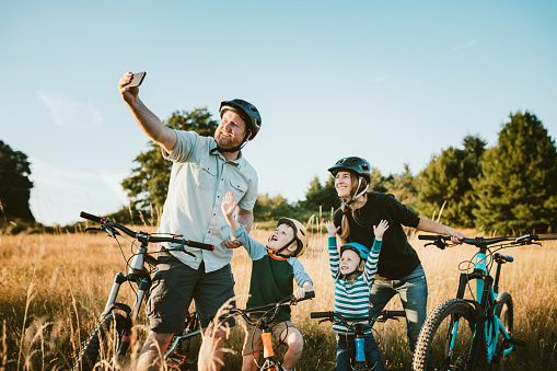 A father and mother ride mountain bikes together with their two small children.  A fun way to spend time together and exercise while on vacation in the Seattle, Washington area.