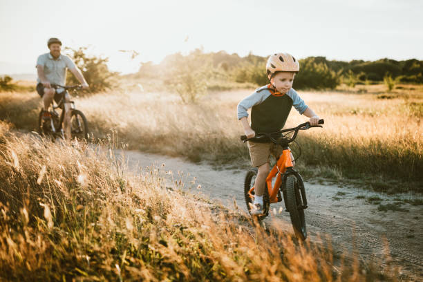 istock Father Teaching Son to Mountain Bike on Sunny Day 1164964962