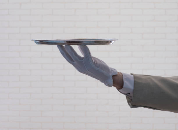 istock waiter in a white glove  holding  a silver tray 1164966663