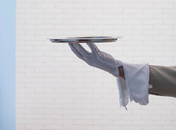 istock waiter in a white glove  holding  a silver tray 1164966816