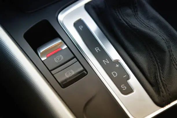 car interior shot on a generic electronic push button of hand brake function