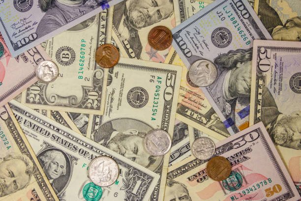 istock Background of different american dollars bills and coins 1164972510