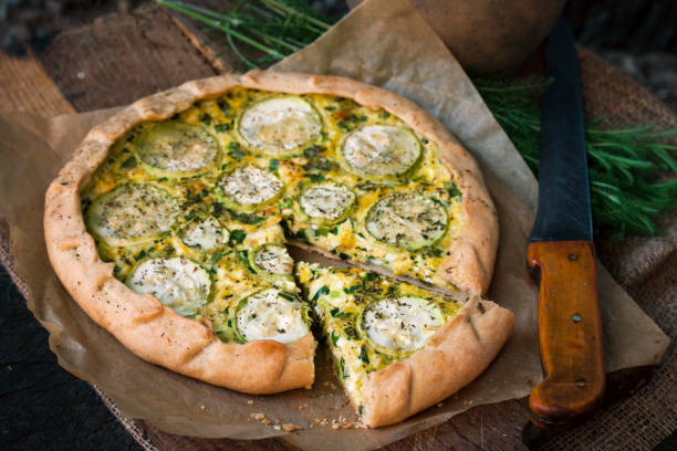 istock Homemade courgette and goat cheese pie on a dark rustic wooden board background 1164973061
