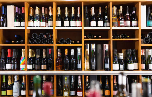rzędy butelek wina na półkach w nowoczesnym sklepie z winami czekają na klientów - wine bottle liquor store wine variation zdjęcia i obrazy z banku zdjęć